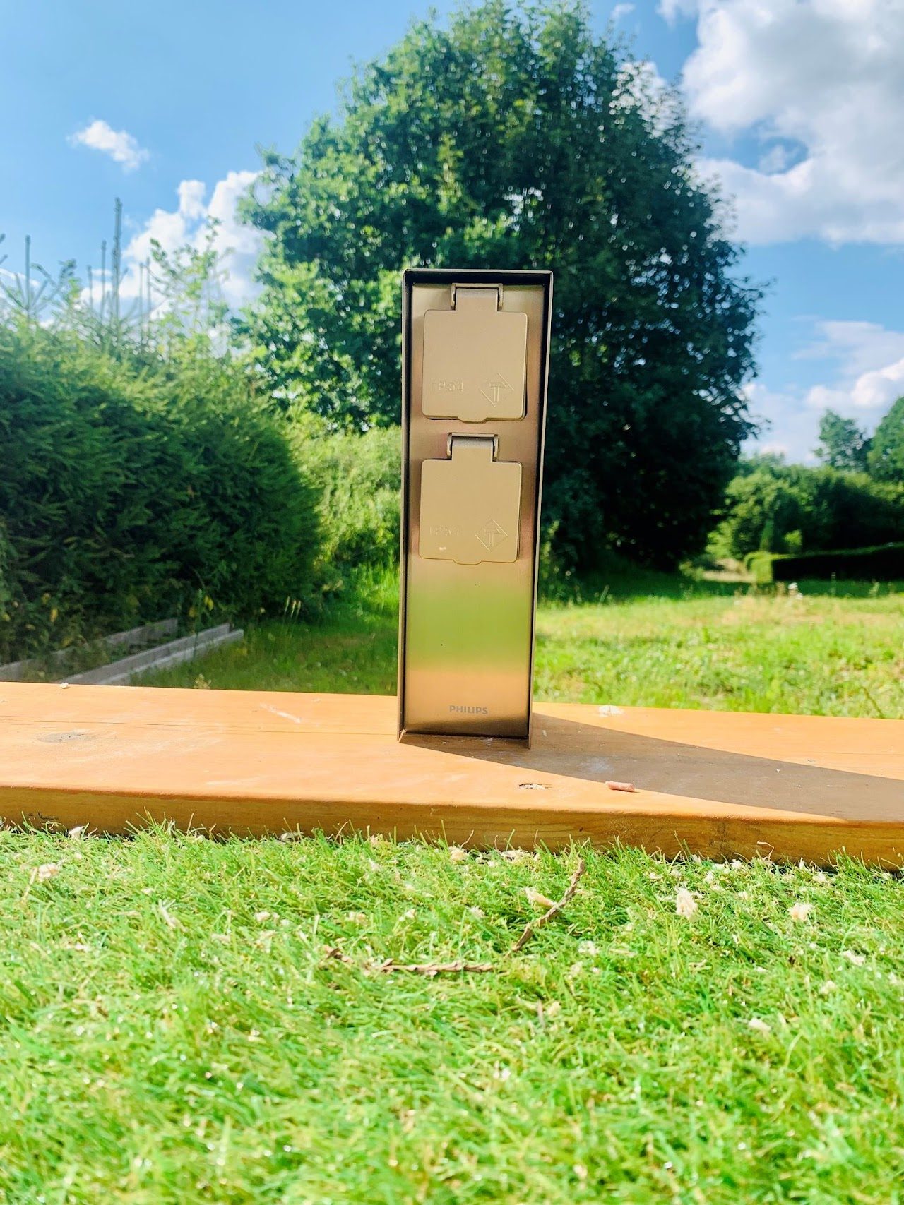 Borne de prises extérieure posée dans un jardin, par Spot'elec